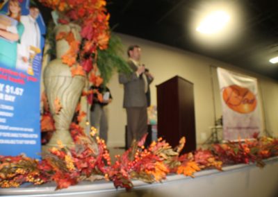 A man standing in front of a podium with leaves on it.